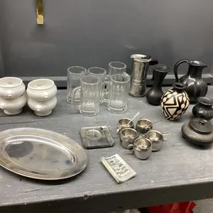 BOX W/ MISC HOUSEHOLD & DECOR ITEMS - TRAMONTINA SS CUPS/PLATES/SPOONS, GLASS STEINS, CERAMIC BOWLS W/ LIONS HEAD, POTTERY