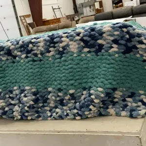 HAND KNOTTED COUCH THROW IN A BLUE RECYCLE TUB