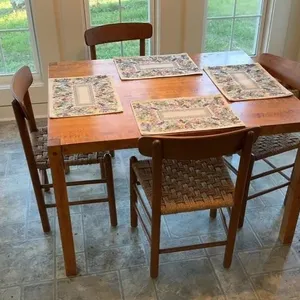Wood dining table with four chairs and placemats
