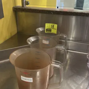 1-gallon poly measuring pitcher. Features a pour spout, side handle, and printed measurement markings.