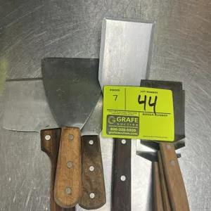 Assorted spatulas and scrapers. Features metal blades with wood handles.