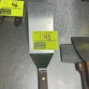 Metal spatula. Features a wood handle. 8"L.