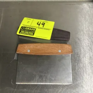 Assorted palm scrapers. Includes 1 wood-handled and 1 plastic-handled scraper. Features straight metal blades with ruler markings.