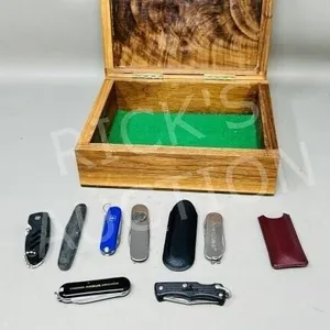 collection of small pocket knives in wood box