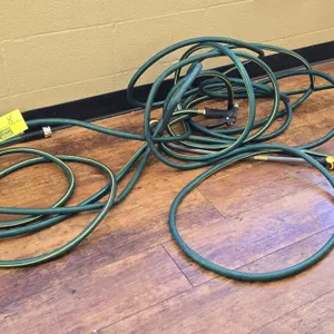 Rubber garden hoses. Features green construction with yellow striping. Includes attached spray nozzles.