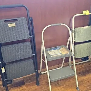Assorted folding step stools. Includes (1) Cosco 2-step stool, (1) HBTower 3-step stool, and (1) 2-step stool. Features tubular metal frames and textu