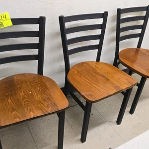 Metal armless chair. Features a solid wood seat and a black ladder back frame.