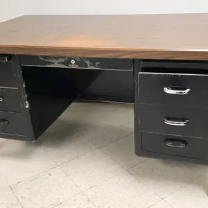 Metal double-pedestal desk. Features a woodgrain laminate top and 7 drawers with silver-tone handles. 5'L.