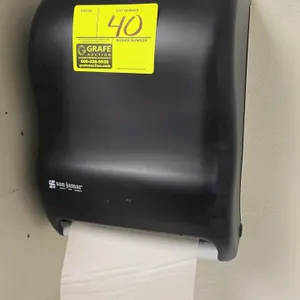 San Jamar paper towel dispenser. Features black plastic construction. Wall-mounted. Contents not included.