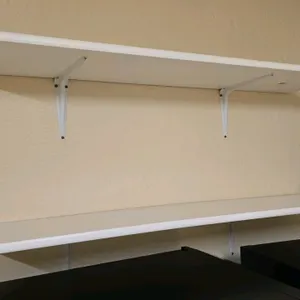 Laminate wall shelving. Includes (2) 4'L shelves. Features a white finish. Mounted on metal brackets.