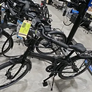 Tern Node D7i DR folding bicycle. Features a black bifold frame design, 7-speed Shimano Nexus grip shifter, front headlight, rear cargo rack, and fron