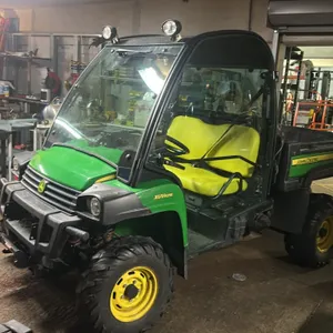 2018 John Deere Gator XUV825E 4x4 utility vehicle. Features an enclosed cab, bench seat, and rear cargo bed. Package includes a 6.5' Boss Smart Shield