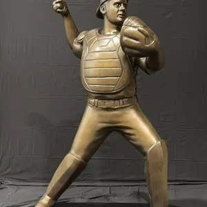 A Joe Mauer Likeness Display Sculpture. Joe Mauer in a catcher's throwing pose, finished in faux bronze. On a portable black wood base (60" x 26" x 72