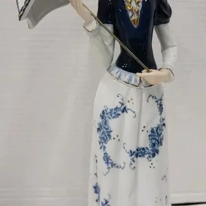 Royal Crown " Victorian Mady holding Umbrella " Porcelain Figurine . Measures 12 ¾" tall . No chips or cracks