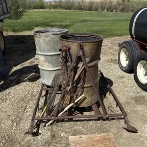 Metal Frame On Skids W/ Burning Barrels
