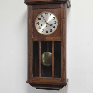 Antique Wall Clock. Winds, Ticks and has a clear chime. Tag on back says Leon Biermann. 13 x 7.5 x 30. BO