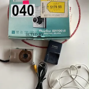 OFFSITE - Canon PowerShot SD1100 IS digital camera with charge cord, accessories, and manuals.