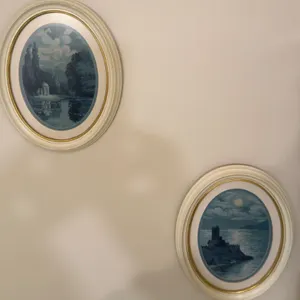 Two Framed Oval Artwork Prints with White and Gold Frames