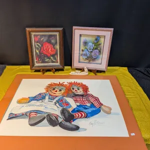 Three Artworks: Raggedy Ann Painting, Floral Embossed Art, and Rose Print