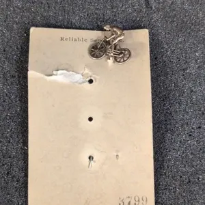 Bicycle rider 2" stick pin, base metal, ca 1930
