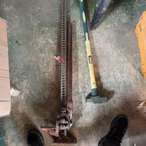 Hi-Lift mechanical farm jack with a steel frame and a yellow-handled sledge hammer Manufacturer deta