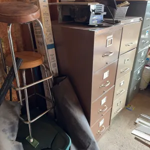 Three 4-drawer metal filing cabinets in brown, tan, and gray finishes. Each cabinet features label h