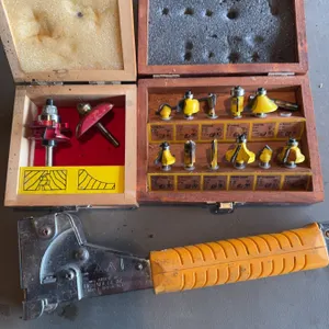 Two boxes of assorted router bits, with nine yellow-handled bits and two red-handled bits, along wit