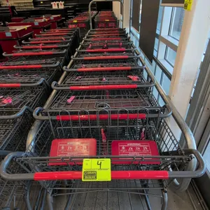 Metal shopping cart. Features wire basket construction, folding child seat area with safety straps, lower wire shelf, and red plastic handle grip. 42"
