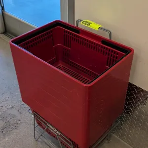 Poly shopping basket. Features red poly construction, dual black folding handles, and Grocery Outlet branding. Includes a metal wire basket holder. 19