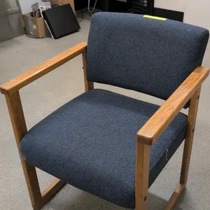 Arm chair. Features blue cloth upholstered seat and back. Mounted on a wood frame.