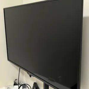 Insignia 42" flat screen TV. Includes remote control and 4K 60Hz HDMI KVM extender receiver. Mounted on an articulating wall mount bracket.