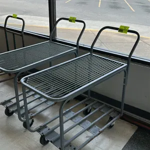 Metal 2-tier transport cart. Features a top wire-grate shelf and bottom slatted shelf. Constructed with a grey-painted steel frame and integrated push