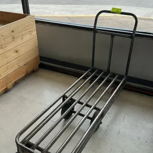 Metal transport cart. Features tubular steel frame construction and a tall integrated push handle. Designed with a 6-wheel configuration featuring cen