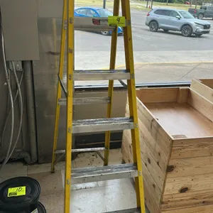 Louisville 6' fiberglass stepladder. Features yellow fiberglass side rails with aluminum steps and a blue plastic top cap with integrated tool slots. 
