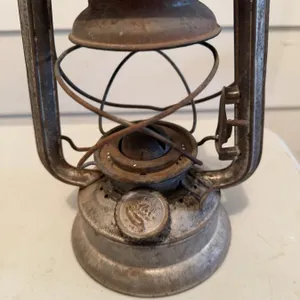 Metal Dietz kerosene lantern. The lantern shows signs of use and age and includes an attached wire h