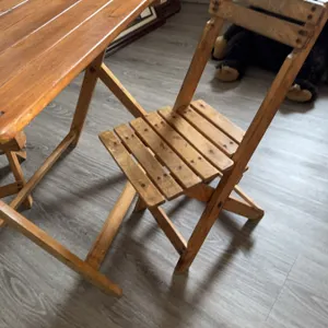 One rectangular folding table and two matching folding chairs. Made of wood with horizontal slat des