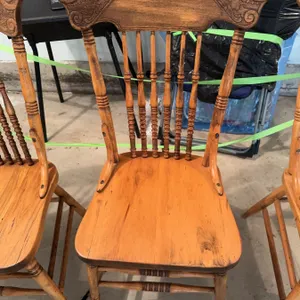 Set of three wood chairs with spindle backs and carved top rails, along with a large rectangular fol