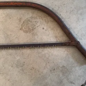 Steel bow saw featuring a curved frame and toothed blade, suitable for cutting wood. The frame displ