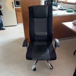 Multiple black office chairs featuring mesh and fabric upholstery, high backs, and armrests. The cha