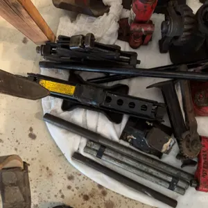 Multiple car jacks including bottle jacks, scissor jacks, a mechanical ratchet jack, iron bars, and 