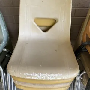 4 yellow hard plastic chairs with metal legs