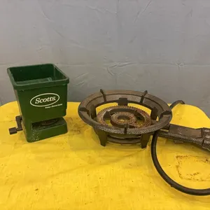 Hand-held fertilizer spreader and cast iron burner