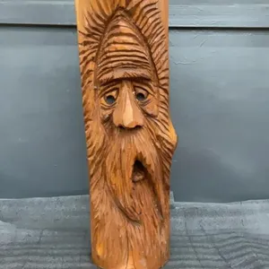 WOOD CARVING OF A FACE OF AN OLD MAN