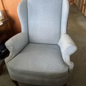 blue wingback chair with a high back and mahogany