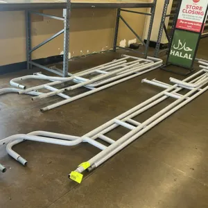 Metal cart corral assembly. Features painted tubular steel frame and rail components. Disassembled. Note: Requires assembly. Background items not incl