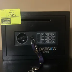 Barska depository safe. Features a black finish, front drop slot, digital keypad, key override, and carpeted interior base. Includes keys. Powered by 