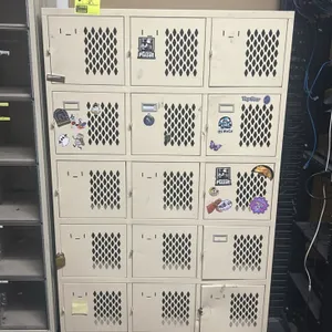Metal 15-door locker. Features a 5-tier configuration, diamond-pattern ventilation cutouts, and latch closures. 41"W x 18"D x 68"H. Note: stickers and