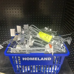 Quantity of assorted pegboard hangers. Features metal display hooks of varying lengths, many with attached plastic price label holders. Housed in a bl