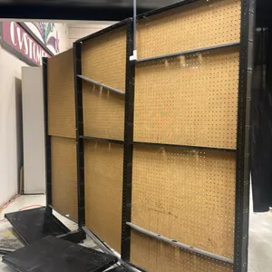 9'L of Lozier wall shelving. Features black metal uprights and base shelves with tan pegboard backing. Stands 74"H with 19"D bases. Includes three 3'L