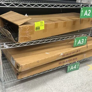 Quantity of assorted new merchandisers on wire racking. Includes three boxed merchandiser display units stored on a three-tier chrome wire shelving un